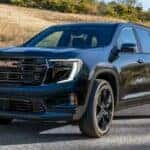 The Family-Friendly And Stylish 2026 GMC Acadia, Driving Past A Golden Hill