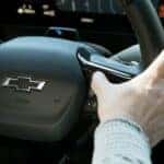 A Knowledgeable Driver Using A Safety Feature By Pressing A Button on The Steering Wheel