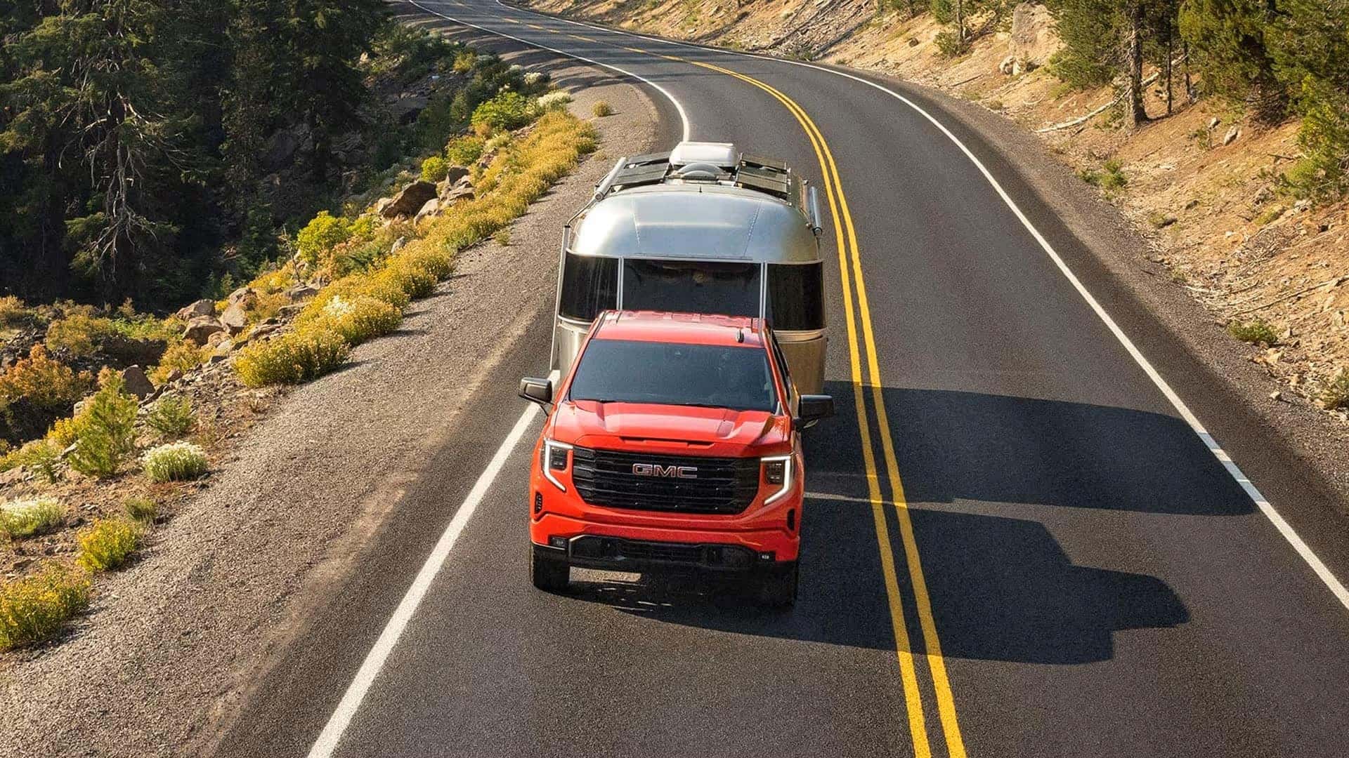 A Red And Mighty GMC Sierra 1500 Towing A Metallic Trailer On The Road Conveniently And With Ease