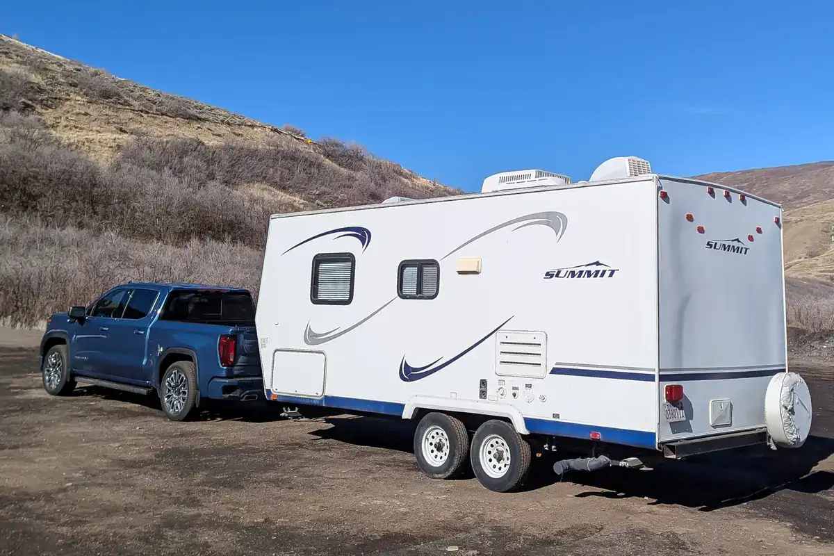 The Brawny GMC Sierra 1500 Denali Ultimate Towing A White Trailer Off-Road