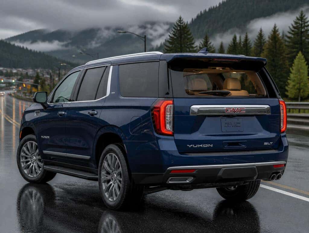 2026 GMC Yukon parked on a wet road in Auburn, WA with evergreen hills in the background