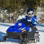 Youth riding snowmobile